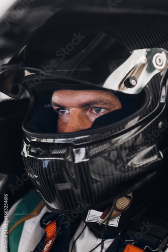 Racing Driver in Carbon Fiber Helmet Sitting Inside Race Car Cockpit During Track Day