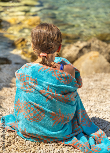 little girl sitting on the beach