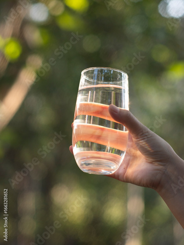 Chinese woman drinking water outdoors in summer
