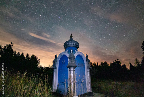 Night starry sky above the obelisk standing on the border of two parts of the world 