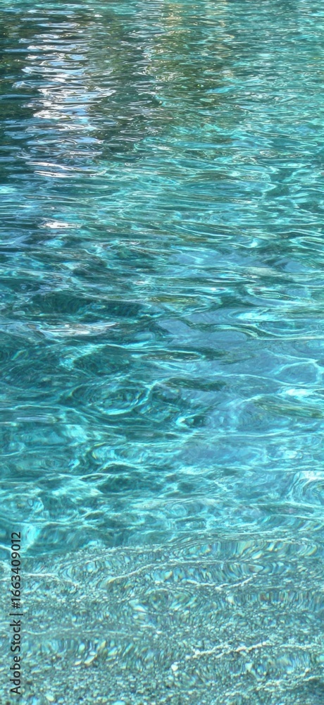 Obraz premium A Tranquil Reflection of Crystal Clear Water Surface with Gentle Ripples and Characteristic Blue Tones Creating a Calming Atmosphere