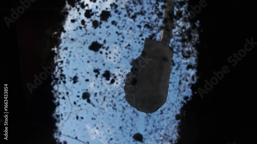 Farmer on summer day fills hole with freshly dug earth using shovel. He fertilizes and digs ground before planting trees and plants. Low angle. POV. Vertical. Below
