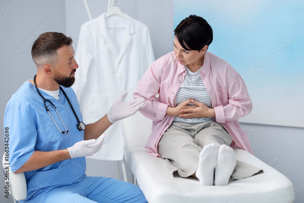Obraz premium Gastroenterologist consulting patient with stomach pain in clinic