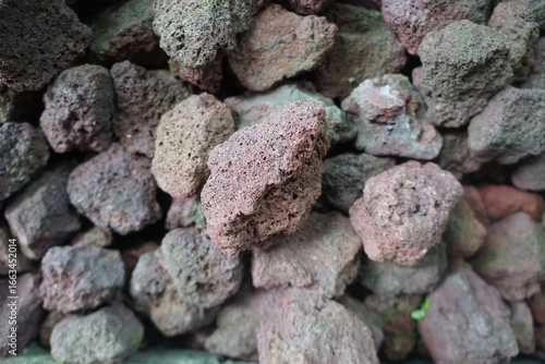 Scoria or cinder is a pyroclastic, a dark-colored igneous rock with abundant round bubble-like cavities known as vesicles. 