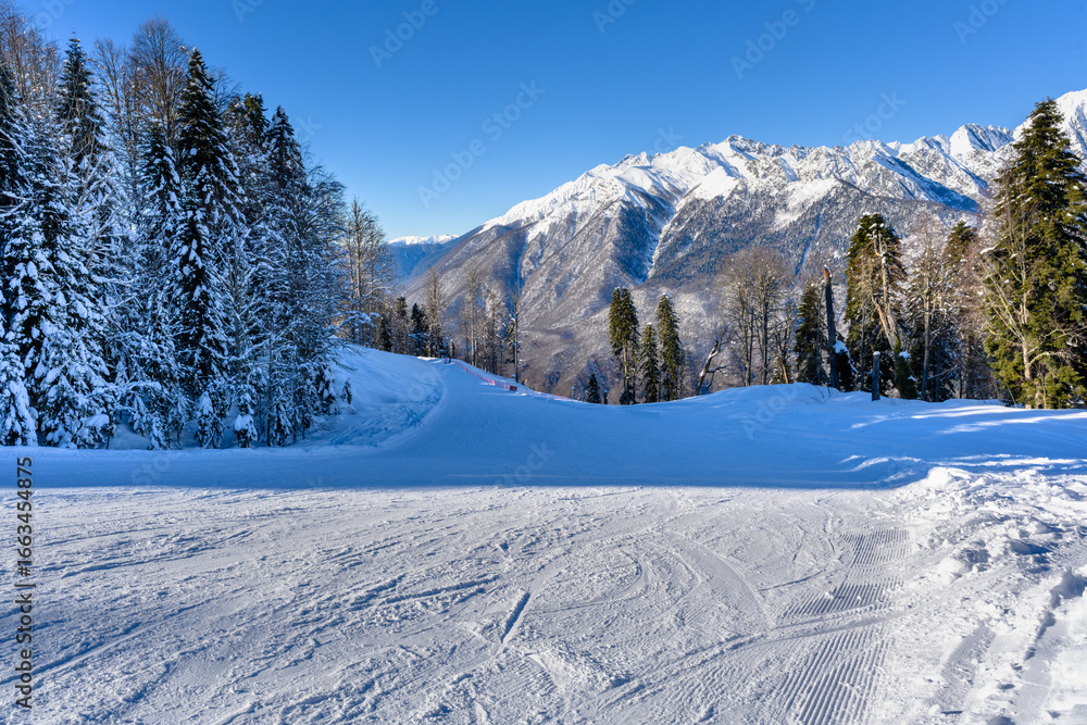 Obraz premium A beautiful winter landscape with a mountain resort and snow on the slopes.