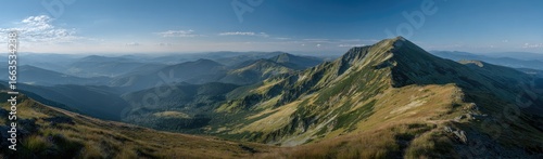 Panoramic mountain vista, showing a rugged mountain range with valleys and ridges, under a partly cloudy, clear blue sky