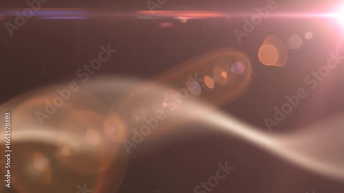 Abstract image featuring a bright lens flare effect with bokeh and light streaks against a dark background.