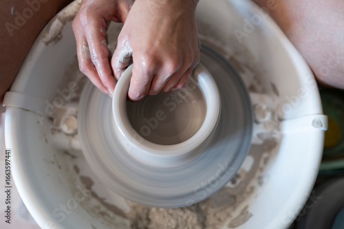 Manos trabajando la ceramica en el torno
