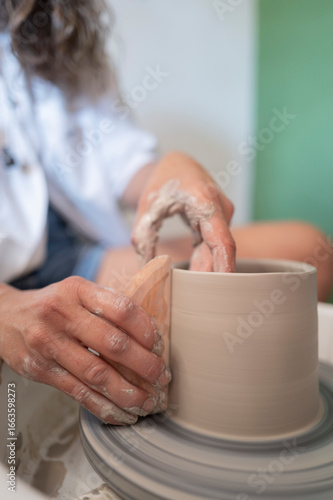 Manos trabajando la ceramica en el torno
