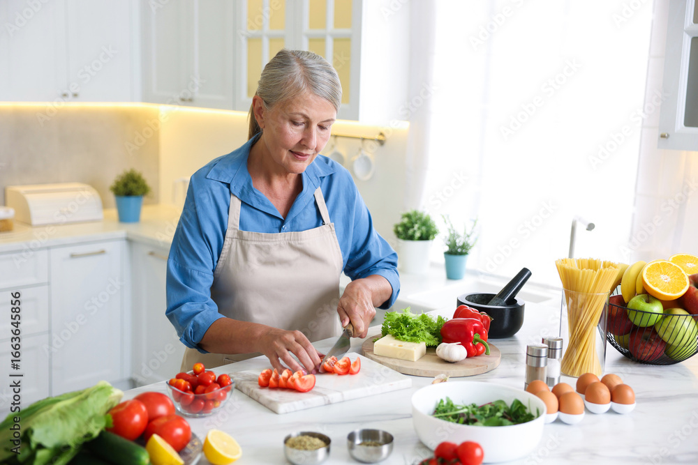 Senior woman cooking at white marble table in kitchen Senior woman cooking at white marble table in kitchen