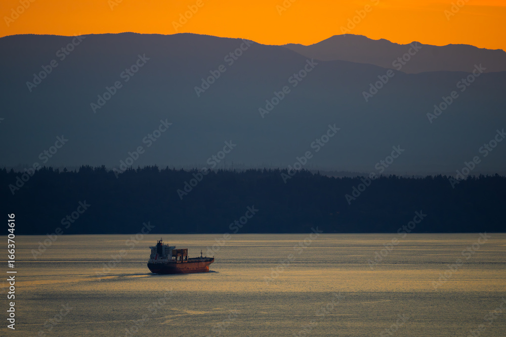 Fototapeta premium Cargo Ship Exits Puget Sound at Dusk