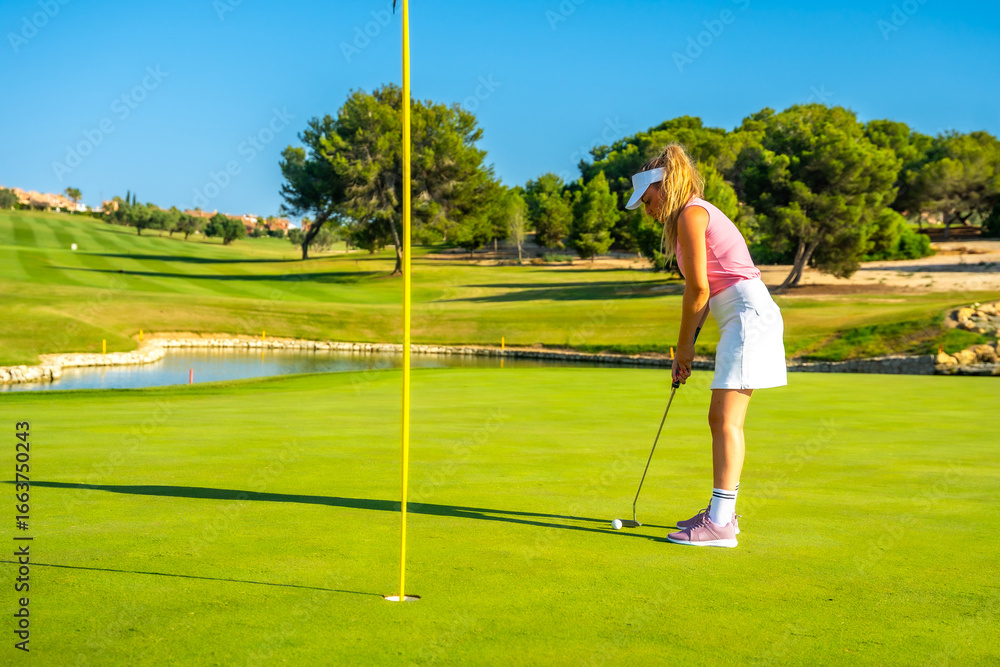 Fototapeta premium Golfer putting ball on green at golf course