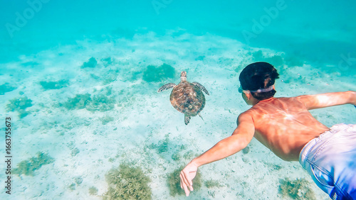 Child swimming with Sea turtle at Port Barton, Palawan, Philippines