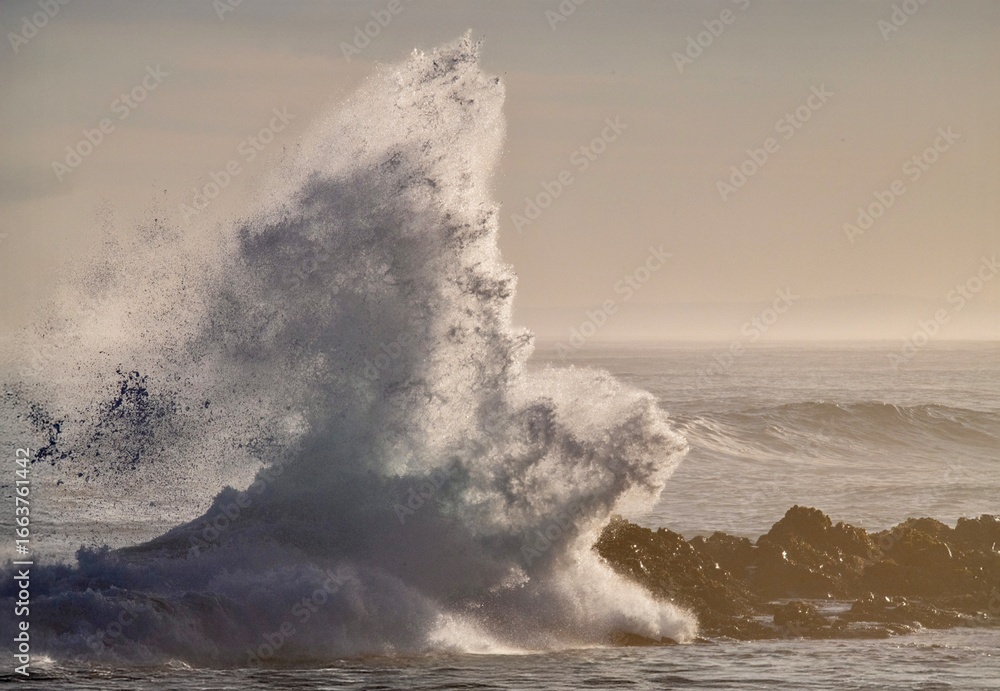 Obraz premium huge waves crashing on rocky beach