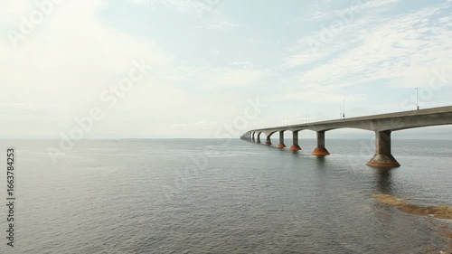 Serene ocean view of confederation bridge stretching to the horizon under a cloudy sky