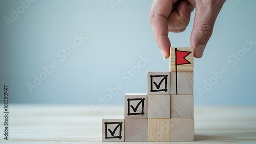 Hand placing final block with red flag on stair-like blocks