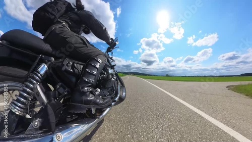 Woman is riding modern naked motorbike on an empty road through a forest with camera view close to the ground level from end of the bike