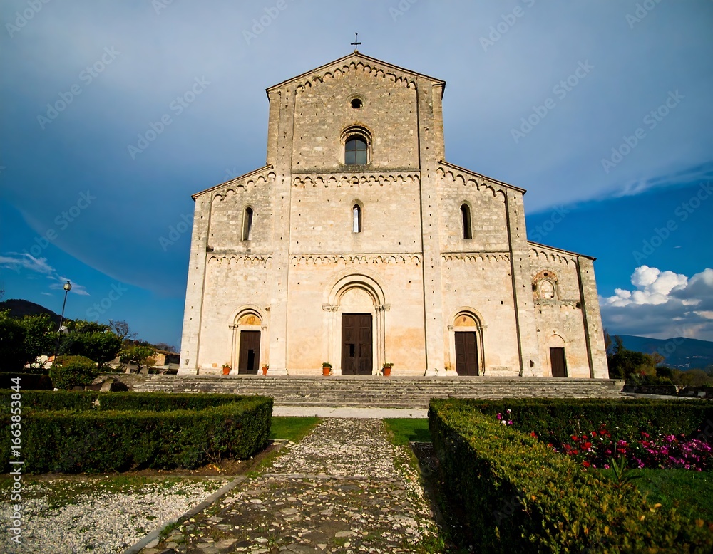 Fototapeta premium Ancient stone church facade, landscaped grounds