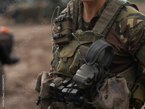 Close-up of military communications and tactical equipment worn by service member