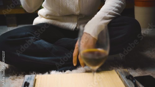 A heterosexual Latino couple having dinner in their living room, sitting on the floor. First-person photography.
