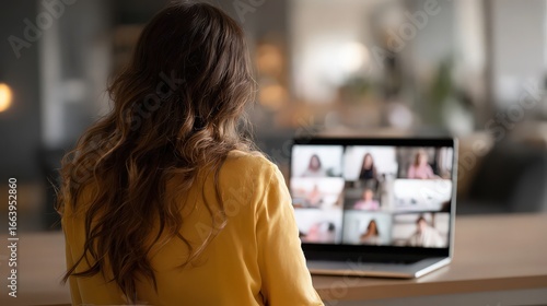 Woman with long hair attending a video conference on a laptop with multiple participants visible