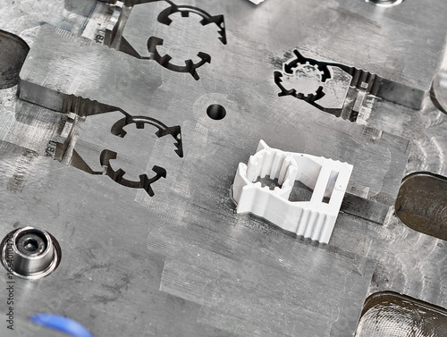 Metal molds for plastic injection molding showcasing a completed component on the manufacturing surface