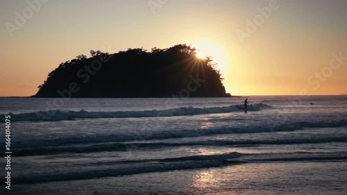 Silhouette of a surfer at sunset.