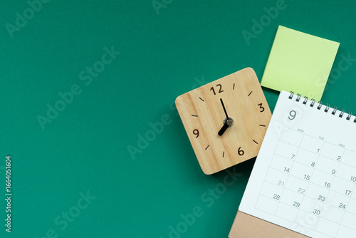 close up of calendar and alarm clock on the green table background, planning for business meeting or travel planning concept
