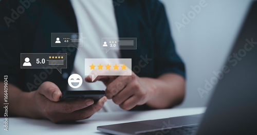 Fotografie Businessman using smartphone with digital customer review and star rating icons,