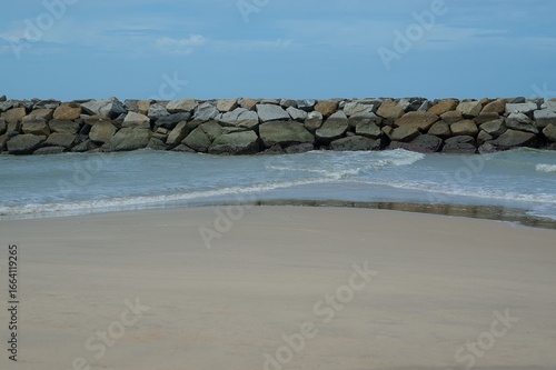A rocky beach with a wall of rocks on the shore