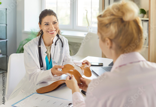 Cuadro en lienzo Orthopedist offering orthopedic insoles to patient at medical office appointment