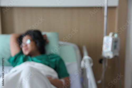 Blurred female patient lying on a hospital bed.