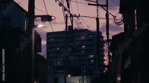 Colorful Tokyo Sunset Framed by Urban Power Grid and Housing – Radiant twilight sky contrasts with silhouettes of residential blocks and thick cable networks.