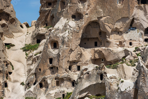 Close-up of cave dwellings of Uchisar castle in tufa cones at Nevsehir Province in Cappadocia, Turkey. House is carved into an sandstone rock formations.
