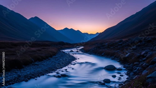 Majestic mountain range with flowing river at dusk creates a tranquil atmosphere, perfect for