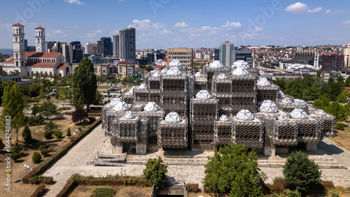 Drone view of the modern Kosovo National Library with the Pristina skyline in the background