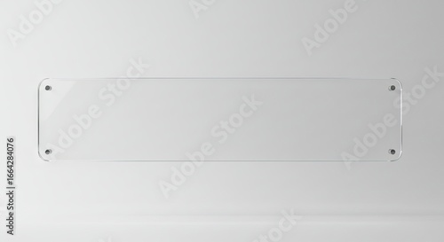 Rectangular transparent plaque mounted on a white wall with metal bolts at each corner