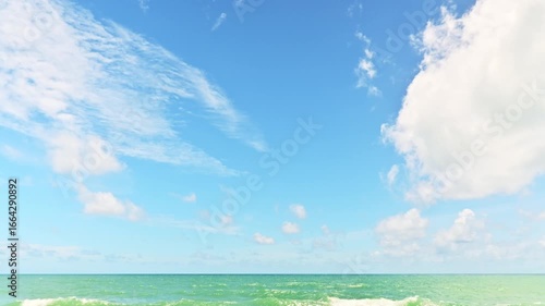 Fast motion of clouds in beautiful sunny day above the ocean. Time lapse cloudy blue sky over the sea in summer time.