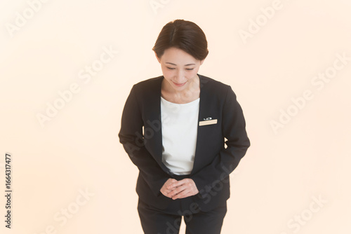 Obraz na plátně ジャケットを着た日本人女性がお辞儀をしている。