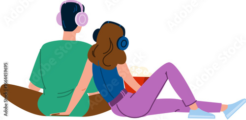Couple wearing headphones watching movie and eating popcorn