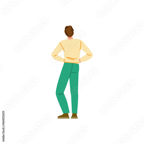 Man standing with hands on hips looking away back view