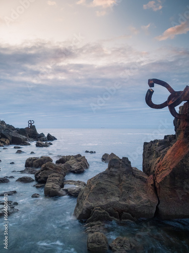 Vertical photo of a seascape with rusty human artifacts