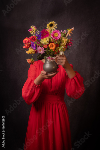abstract renaissance portrait of anonymous girl in red dress holding a small vase with colorful dahlia flowers hiding her face
