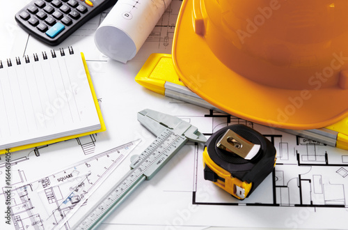 Architects concept, project house, Construction plans with yellow helmet and drawing tools on blueprints, of engineering tools on work table,
