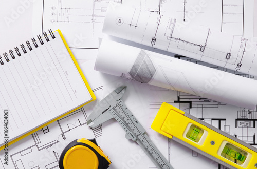 Architects concept, project house, Construction plans with yellow helmet and drawing tools on blueprints, of engineering tools on work table,