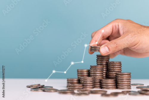 Invest,Investment,profit,saving money and planning businesses. Man holds coin in his hand with coins stack and upward arrows Indicating profit and growing