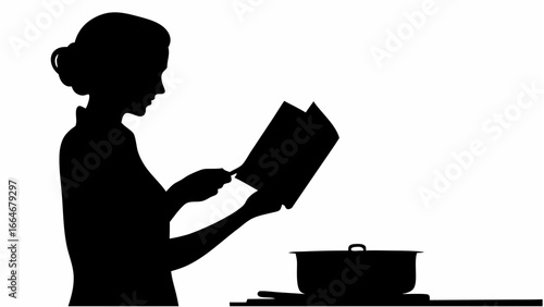 Silhouette of a woman reading a cookbook while cooking with a pot on the stove in the kitchen area