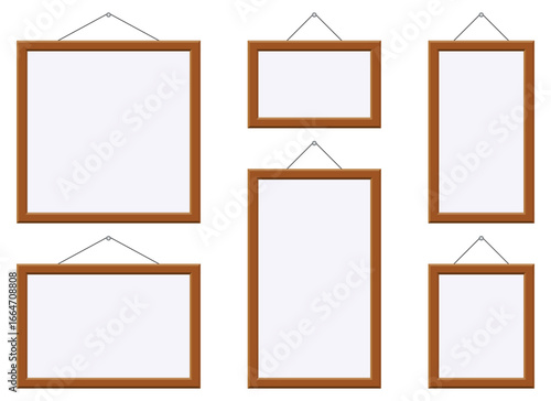 Isolated against a white background are six empty frames of varying sizes and orientations, each suspended from a thin wire, creating a clean and minimalist display.