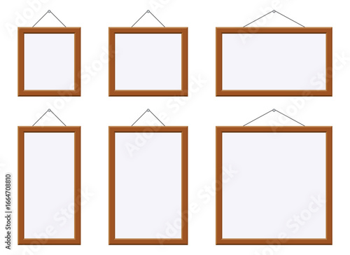 A collection of six empty frames is displayed, each with a light brown border. They hang suspended by wires. The frames are of different shapes and sizes.