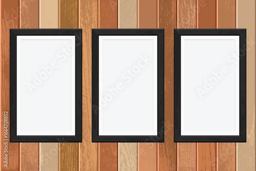 Three empty picture frames with black borders stand against a varied brown wooden wall. They're vertically aligned providing ample space for pictures.